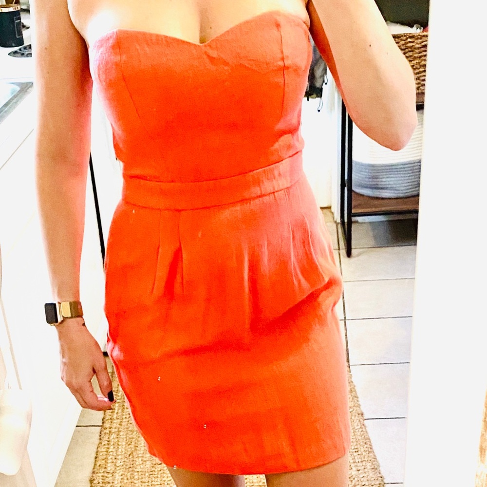 Salmon colored strapless dress.